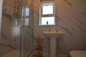a bathroom with a sink and a shower with a window at An Grianán Getaway in Burt +19 photos