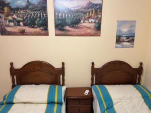two beds in a room with paintings on the wall at Apartamento Torrox5 in Torrox Costa