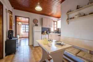 a kitchen with a table and a white refrigerator at Guest House Sklithro in Sklíthron +35 photos