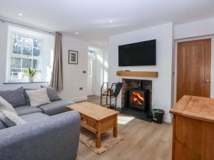 a living room with a couch and a fireplace at Gate House in Llangefni