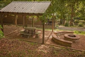 a gazebo with a picnic table and a bench at Stefan Cabin Nature-nested Tiny Home Hot Tub in Chattanooga