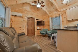 a living room with a couch and a bar in a cabin at Stefan Cabin Nature-nested Tiny Home Hot Tub in Chattanooga
