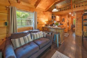 a living room with a couch in a log cabin at Thomas Cabin Forest Tiny Cabin With Hot Tub in Chattanooga