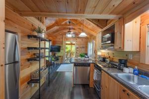 a large kitchen with wooden walls and wooden flooring at Thomas Cabin Forest Tiny Cabin With Hot Tub in Chattanooga