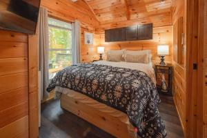 a bedroom with a bed in a wooden cabin at Thomas Cabin Forest Tiny Cabin With Hot Tub in Chattanooga