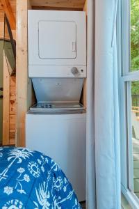 a microwave sitting on top of a refrigerator next to a window at Thomas Cabin Forest Tiny Cabin With Hot Tub in Chattanooga +24 photos
