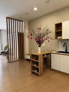 a kitchen with a table with a vase of flowers on it at Ceilé Stay Đà Lạt in Da Lat