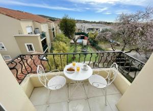 a balcony with a table and chairs on a balcony at Aux Chti Bains in Balaruc-le-Vieux