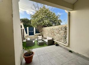 a patio with couches and a stone wall at Aux Chti Bains in Balaruc-le-Vieux