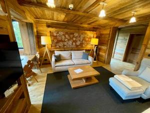 a living room with a couch and a table at Luxus Chalet in Oberstaufen inkl Wellness Pool und Bergbahnen in Oberstaufen