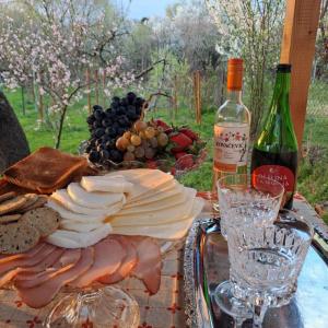 a plate of cheese and grapes and a bottle of wine at Stan in Zrenjanin