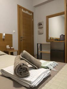 a bedroom with towels on a bed with a mirror at Lemonaki House Lefkada in Asprogerakata