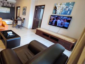 a living room with a couch and a flat screen tv at Sunshine Suites Times square KL in Kuala Lumpur
