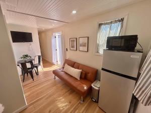 a living room with a couch and a refrigerator at Quail Run Farm- Rustic Tiny Home 2 in Chattanooga