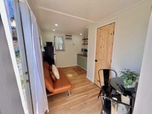 a living room with a couch and a kitchen at Quail Run Farm- Rustic Tiny Home 2 in Chattanooga