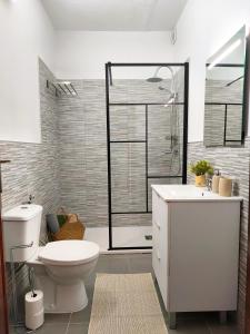 a bathroom with a toilet and a glass shower at Alma Del Sur Tenerife in Arona +33 photos