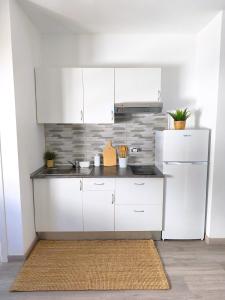 a kitchen with white cabinets and a white refrigerator at Alma Del Sur Tenerife in Arona