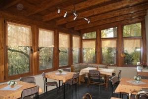 a dining room with tables and chairs and windows at Pension Fischer in Plauen