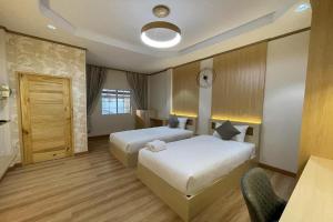 a hotel room with two beds and a clock on the wall at BB house & resort in Ban Thum