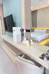 a room with a desk with a television and a bed at BB house & resort in Ban Thum