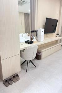 a room with a desk with a chair and a television at BB house & resort in Ban Thum