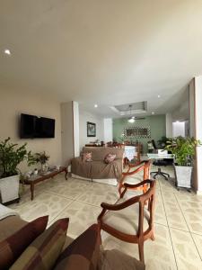 a large living room with a couch and a tv at Hostal El Recreo in Barranquilla