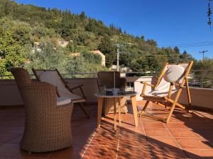 a group of chairs and a table on a balcony at Lemonaki House Lefkada in Asprogerakata