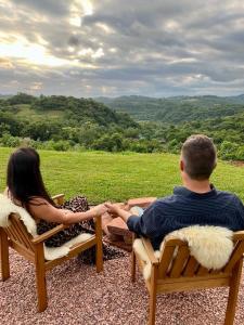 a man and a woman sitting on chairs holding hands at Cabanas Monte Belo in Santa Cruz do Sul +6 photos