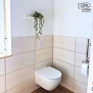 a bathroom with a toilet and a plant at Modern - zentral - Studio mit Küche - Self Check In in Bad Nauheim +11 photos