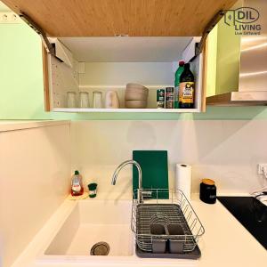 a kitchen counter with a sink with a dish drying rack at Modern - zentral - Studio mit Küche - Self Check In in Bad Nauheim