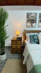 a bedroom with a bed and a nightstand with a plant at ViladaBaleiaBranca in Remédios