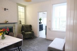 a living room with a table and a fireplace at Sunrise Properties in Barnstaple