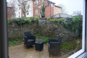 two chairs and a table in front of a stone wall at Sunrise Properties in Barnstaple +4 photos