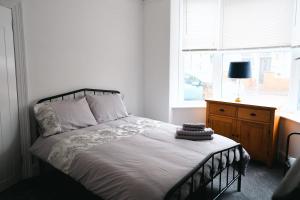 a bedroom with a bed with a dresser and a window at Sunrise Properties in Barnstaple