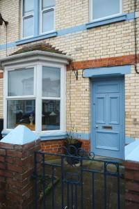a blue door on a brick house with a bench at Sunrise Properties in Barnstaple