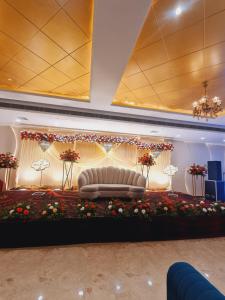 a stage with a couch in a room with flowers at The grand regency in Rāmpur