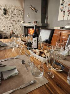 a table with wine glasses and a bottle of wine at La Méridienne - Chambres d'hôtes in Venterol