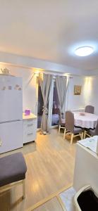 a living room with a table and a white refrigerator at Urban Pool & Relax Apartment in Sarajevo