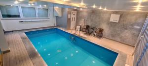 a large swimming pool with a table and chairs at Urban Pool & Relax Apartment in Sarajevo