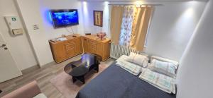 a living room with a couch and a tv at Urban Pool & Relax Apartment in Sarajevo