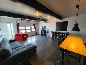 a living room with a couch and a table at Aux 4 vents - Auberg'Inn in Carleton-sur-Mer