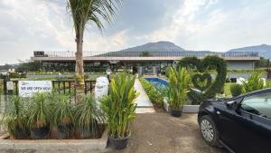 a car parked in front of a building with plants at 7 Tree Resort & Restaurant in Pune