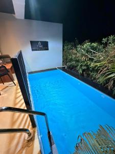 a large blue swimming pool in a room with plants at 7 Tree Resort & Restaurant in Pune