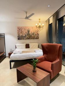 a bedroom with a bed and a chair and a table at 7 Tree Resort & Restaurant in Pune