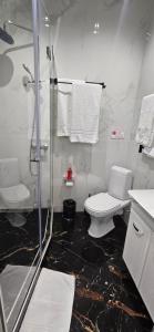 a bathroom with a shower and a toilet and towels at Hotel GLORIA in Ceadîr-Lunga