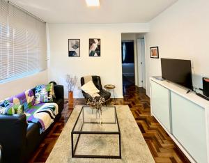 a living room with a couch and a tv at Barriga Verde in Florianópolis +11 photos