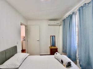 a bedroom with a bed with blue curtains and a mirror at Barriga Verde in Florianópolis