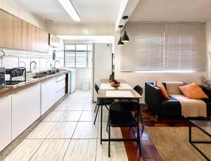 a kitchen and living room with a couch and a table at Barriga Verde in Florianópolis