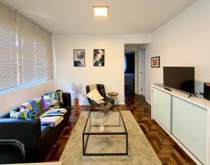a living room with a couch and a tv at Barriga Verde in Florianópolis