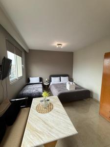 a room with two beds and a table in it at Alpha Apartments 42 in Serres